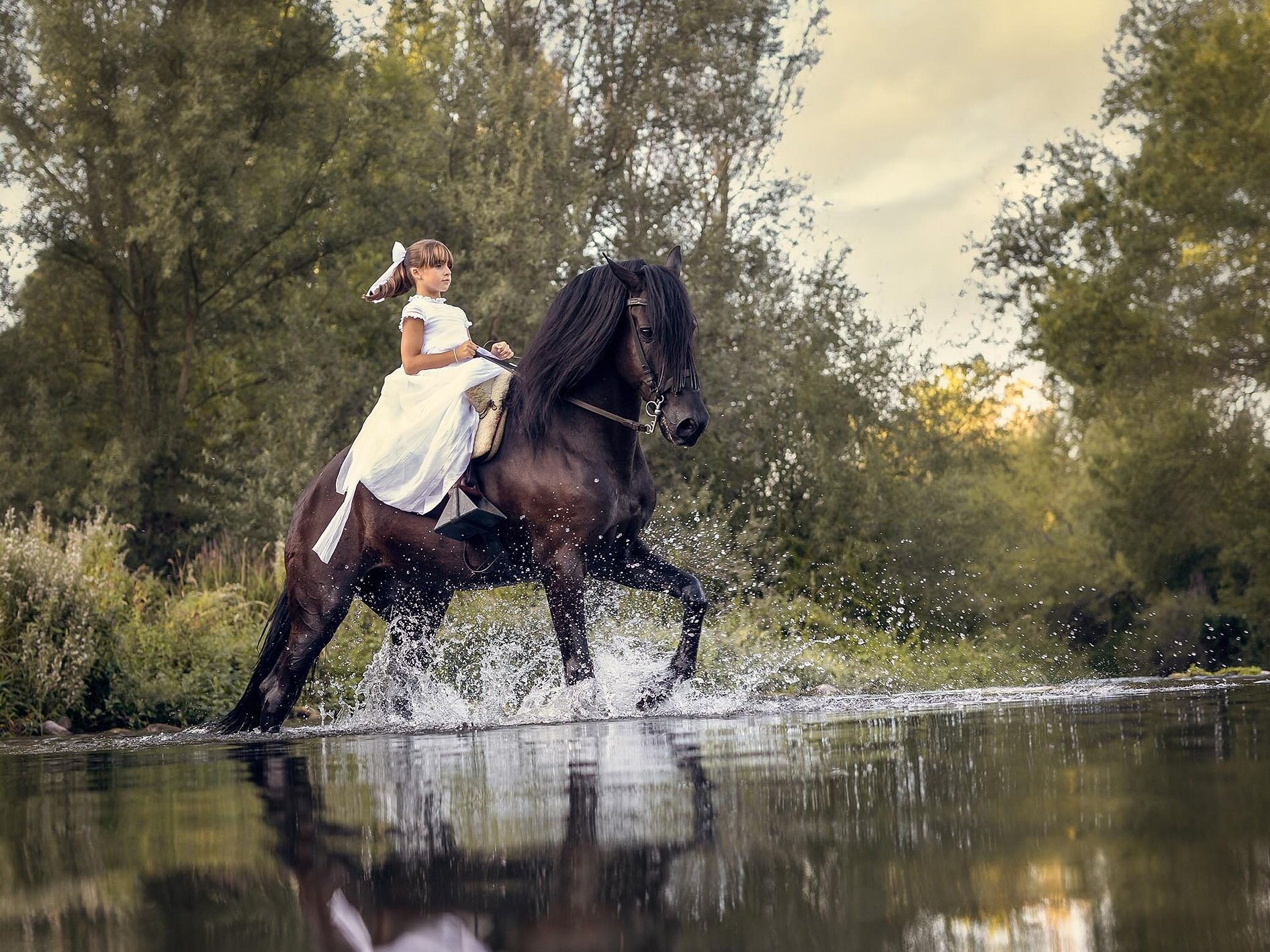 Comuniones en caballo Niña de comunión cabalgando en el río junto a su precioso caballo.